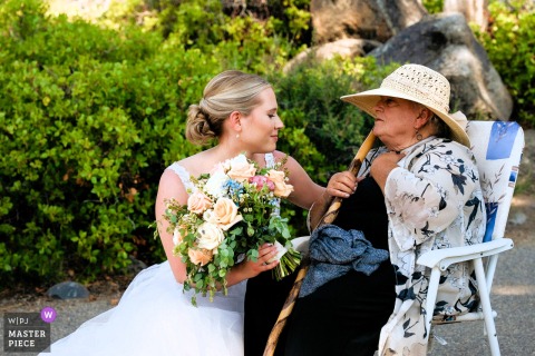 At Lake Tahoe, in a quiet corner, the bride shares a tender moment with her grandmother, expressing love and respect for the woman who has quietly observed her journey—capturing warmth and deep family connection on the wedding day.