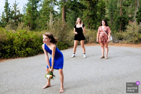 In South Lake Tahoe, the flower girl steps in for the bouquet toss, leaving only two guests competing to catch it. The playful moment captures suspense and laughter during a lighthearted wedding tradition.