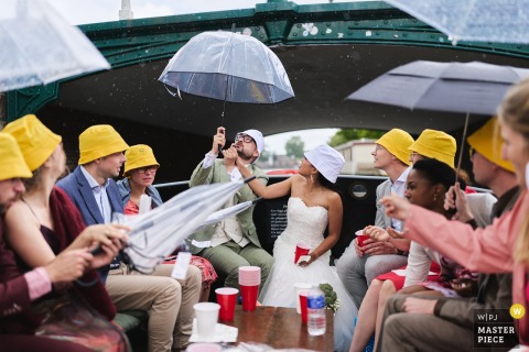 In Amsterdam, Noord Holland, the groom prepares for approaching rain while on a boat, capturing a candid and playful moment amid the city’s iconic canals and timeless wedding atmosphere.