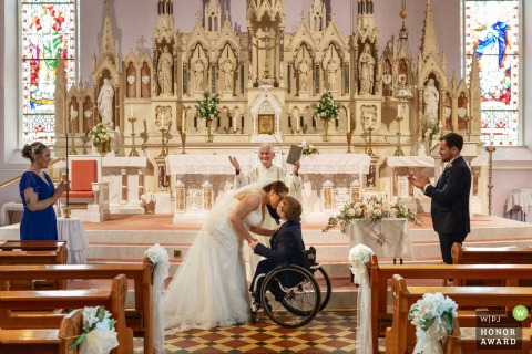 Inside Clonmany Church, Co Donegal, Ireland, the couple shares their very first kiss as newlyweds, surrounded by family and friends.