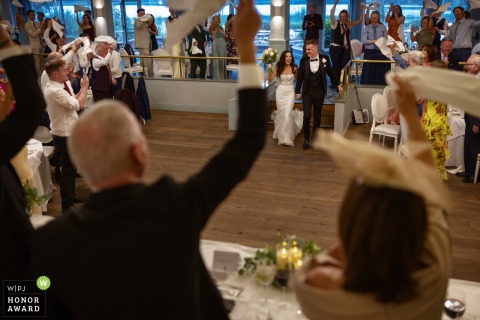 At Harveys Point Hotel in County Donegal, the couple makes a grand entrance to the reception room, welcomed by cheering guests and proud parents in the foreground.