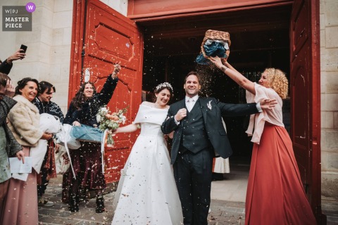Outside the church of Sceaux, France, the newly married couple emerges to a joyful shower of confetti from their guests. The scene brims with excitement, celebration, and vibrant energy marking the start of their new life together.