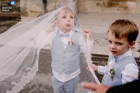 In Orleans, two boys embody kid spirit as they play with and beneath the bride’s flowing veil train. The candid moment adds a sense of whimsy and joy to the wedding celebration.