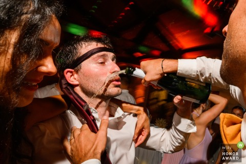 On the dance floor at Château Flojague, guests celebrate with champagne in hand, enhancing the vibrant, joyful spirit of the wedding evening.