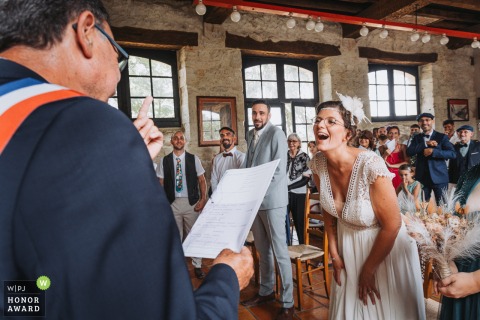 At the town hall of La Sauvetat in Gers, France, the local village mayor shares jokes and brings laughter to the bride and groom during the ceremony.
