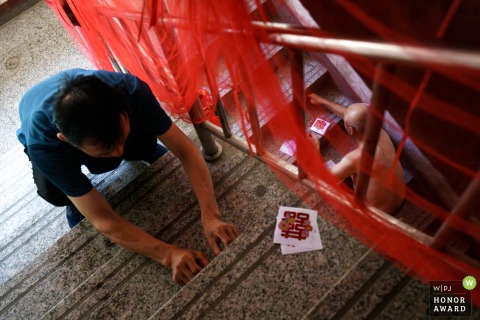 Inside the home in Taiyuan, Shanxi, relatives and friends of the bride fill the hallway with excitement, adding festive decorations and warmth to the wedding atmosphere.