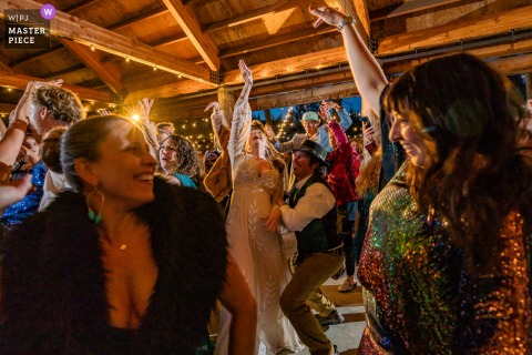 A vibrant party scene at The Hideout in Kirkwood, CA, as the bride dances at the center of the floor, surrounded by lively wedding guests—capturing the festive energy and joy of the celebration.