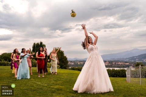 Villa Dolceacqua, set in Oggiono near Lake Como, Italy, hosts a lively bouquet toss as the bride throws her flowers enthusiastically to a group of hopeful single guests.