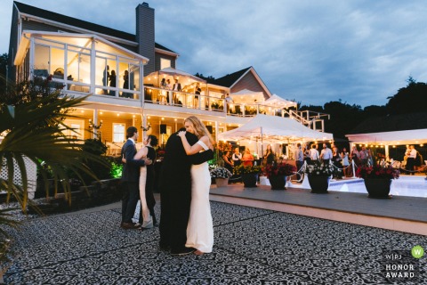 A Father And Daughter Dance Together In A Cozy Maryland Backyard Highlighting Joyful And Significant Family Milestones In a cozy Maryland backyard, a father dances with his daughter while a mother shares the dance floor with her son, highlighting the family’s joyful milestones.