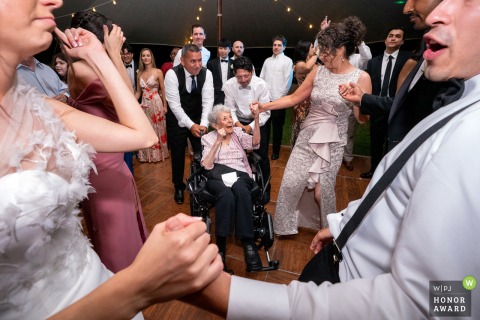 During a reception at a private residence in Potomac, Maryland, the bride’s grandmother dances with family, beautifully framed between the newly married couple.