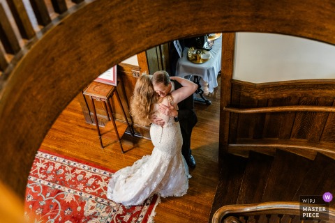 This emotional moment was captured and documented from above at Martha's Bed and Breakfast in Lincoln, NE, as the father of the bride hugs his daughter after seeing her in her wedding gown.