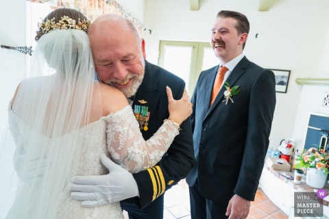 A touching example of wedding photojournalism, this image captures the father of the bride in his military uniform embracing his daughter at Portola Inn, Atascadero, California.