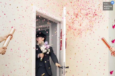   A dramatic scene unfolds at home in Fujian, China, as the groom makes his entrance and celebratory fireworks light up the room, marking a vibrant start to the festivities.