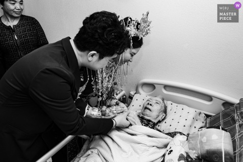 Inside Their Fujian, China Home, The Newlyweds Tenderly Say Farewell To Their Bedridden Grandmother, Honoring Family Across Generations. Inside their home in Fujian, China, the newlyweds tenderly say goodbye to the bedridden, paralyzed grandmother, sharing a moment of love and farewell that honors family across generations.