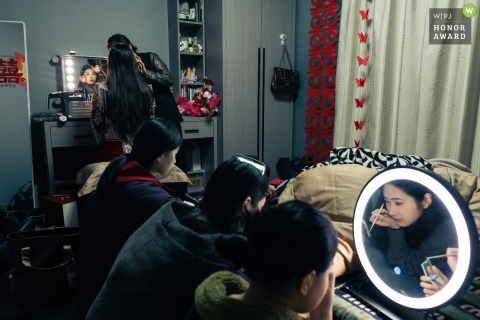 The bride and her bridesmaids prepare for the wedding day at home in Fujian, China, as they get ready together.