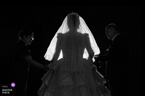   The bride’s parents walk lovingly at her side, accompanying her to the wedding ceremony at the venue in Taian, Shandong, showing their support and happiness on her big day.
