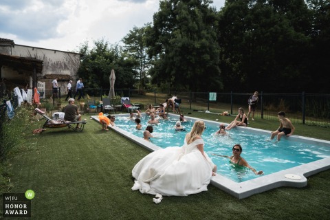 The bride, at the pool, enjoys unforgettable wedding moments within Château La Hitte in France, her day highlighted by the romantic château setting.