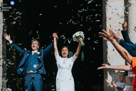 After The Ceremony At Moirax Church, Newlyweds Emerge To Confetti And Cheers, Marking Their Joyful Exit Into Married Life. The couple steps from church into the world as newlyweds, greeted by friends and family and confetti after the ceremony at Moirax, making for a memorable exit.