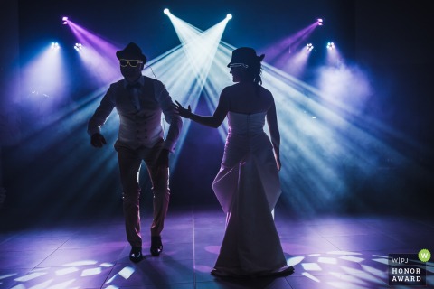 At Domaine de la Chevalerie in Angers, the couple shares their first dance in the dark, their silhouettes highlighted in the romantic ambiance of the blue and purple lights at the reception venue.