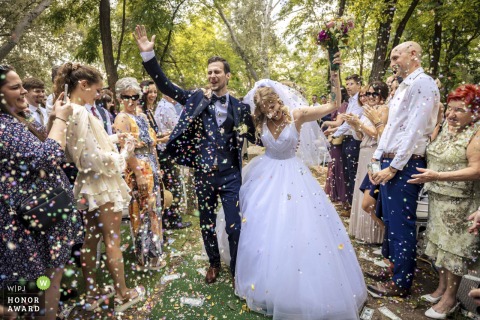 Hand in hand, the newlyweds step forward at their Budapest ceremony location, surrounded by cheers and falling confetti as their celebration truly begins.