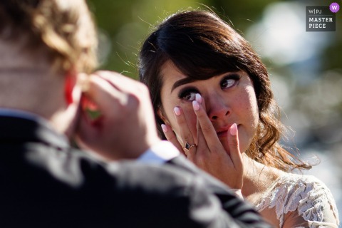  At Lunch Rock, tears of happiness are shared as the bride and groom wipe their eyes while exchanging heartfelt vows.