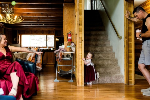 At Heavenly Ski Resort in South Lake Tahoe, California, a child peeks playfully from a stairwell, giggling with her parents.