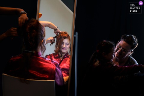   Wedding preparations in Gers, France are filled with smiles as the bride gets ready, her aunt and daughter play and laugh nearby, joy infusing every detail of the day.