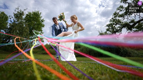 The Bride Attempts To Escape A Playful Trap On The Lot-et-Garonne Dance Floor While Guests Cheer Her On. The bride attempts to break free from a playful “trap” on the dance floor at the reception venue in Lot-et-Garonne, as guests watch her determined, lighthearted effort.