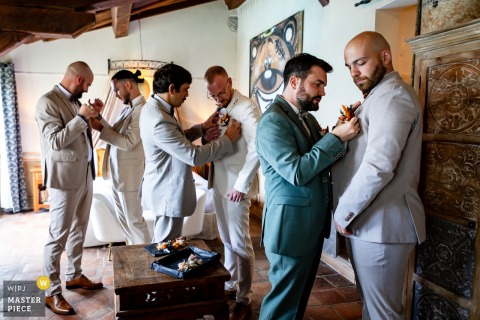 The Groom And Groomsmen Finalize Dress Preparations At Domaine Des Saints Pères, Montagnole, Savoie, Before The Ceremony Begins. The final touches of preparation unfold at Domaine des Saints Pères in Montagnole, Savoie, France, with the groom and his groomsmen getting ready for the ceremony together.