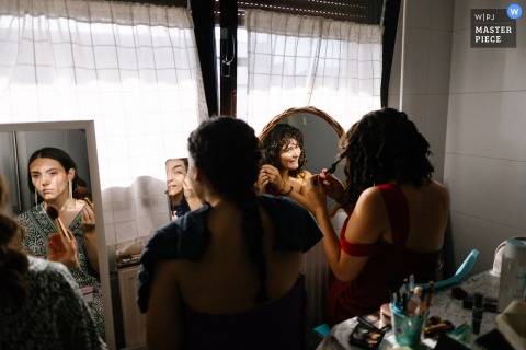 Laughter And Makeup Fill The Bride’s House In Pamplona, Spain, As Sisters Excitedly Prepare Together For Wedding Festivities. In Pamplona, Spain, the bride’s house buzzes with excitement as her sisters gather together, applying their makeup and preparing for the wedding festivities ahead.