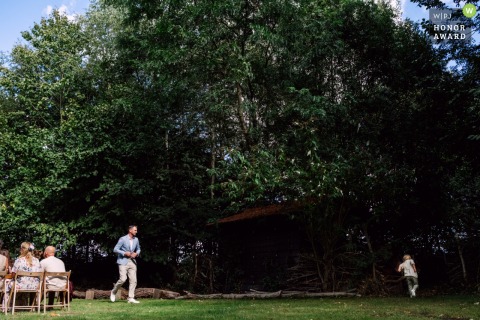 At Land van Es in Strijen, Netherlands, one curious young guest decides to explore the surroundings rather than sit through the ceremony, providing a touch of whimsy to the occasion.