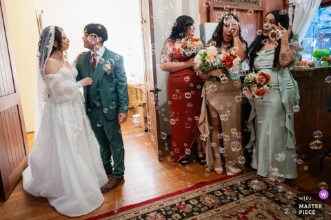  The wedding party erupts in bubble celebration at 1909, Malibu, CA as the bride and groom lead their friends and family indoors after exchanging vows at their outdoor ceremony.