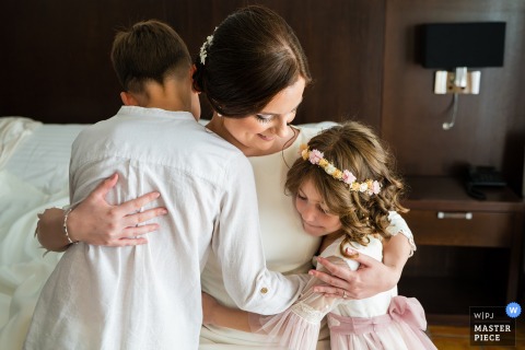   The bride finds comfort and calm sitting with two children in a quiet room at Hotel HO Jaén, Spain, soaking in a relaxed moment before the busy wedding day unfolds.