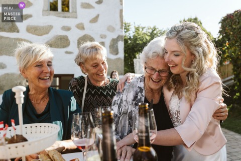 Generations Connect In Quiet Reflection At Lesterhof In Austria As The Bride Shares A Special Reception Moment. At Lesterhof in Austria, the bride shares a quiet, intimate moment with female relatives representing multiple generations, highlighting the enduring bonds of family during the reception.