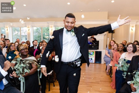 At Breaux Vineyards in Purcellville, Virginia, the unconventional flower man walks confidently down the aisle, delighting guests at the indoor ceremony venue.