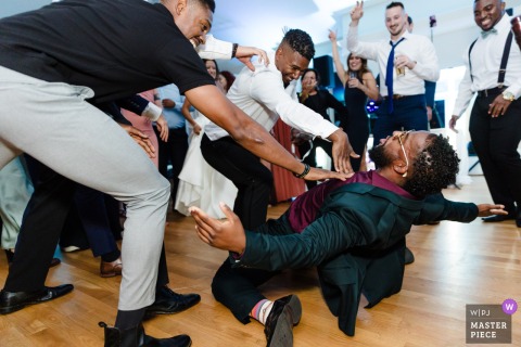 Active men fill the dance floor at Breaux Vineyards in Purcellville, VA, as music and laughter fuel a vibrant wedding celebration among the rows of Virginia vines.