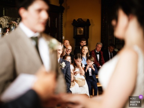 Wonder Fills Children’s Eyes At Chettle Lodge In Dorset, UK, As They Absorb The Ceremony From Special Seats. Chettle Lodge in Dorset, UK, provides a unique perspective as children experience the wedding ceremony, taking in the sights and sounds from a viewpoint filled with wonder.