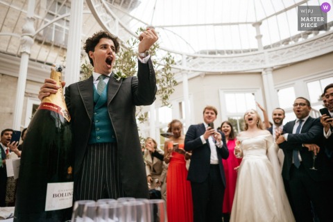Rajasthan Champagne Becomes A Uniting Toast As Came House Guests In Dorset, England, Gather For A Single Pour. At Came House in Dorset, guests gather round as everyone is about to be served champagne from a single bottle, fostering a sense of unity and celebration throughout the crowd.