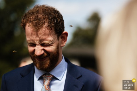 Guests React To Unwanted Bee Attention At The Larmer Tree, Dorset’s Picturesque Garden Wedding Venue. The Larmer Tree in Dorset, UK, comes alive as a guest reacts to feeling of under attack by bees, at this picturesque garden venue.
