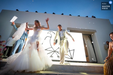 Tradition Thrills Wedding Guests During The Glass-Smashing At Odera Hotel In Tinos, Greece, Marking The Moment With Cheers. During a wedding at Odera Hotel in Tinos, Greece, the tradition of glass smashing adds excitement and cultural flair to the celebration, marking the moment with joyful cheers.