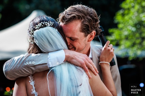A Heartfelt Hug Follows An Emotional Speech For The Wedding Couple At Salon Van Fagel In Intimate Amsterdam Setting. The wedding couple share a heartfelt hug after an emotional speech at Salon van Fagel, surrounded by friends and family in an intimate Amsterdam setting.