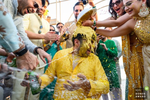 A lively Haldi celebration unfolds at the Hilton in Abu Dhabi, as friends escalate the fun with every tool at their disposal, beer bottles included, for the bride and groom.