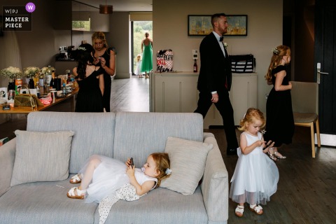   Bridal preparations at Thornhill Hotel in Hampshire, UK, are a mix of chaos and calm, with several flower girls occupying themselves in unique and entertaining ways in the busy room.