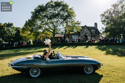 Following their London wedding ceremony, the bride and groom make a stylish exit in a classic car, waving farewell to guests as they begin their journey together.