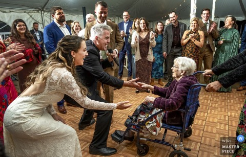 The Bride Shares A Special Dance With Her Grandmother In A Wheelchair At Echo Lake Inn In Tyso, Vermont. At Echo Lake Inn in Tyso, Vermont, the bride shares a special dance with her grandmother, who remains in her wheelchair, as the singer performs nearby and guests look on lovingly.