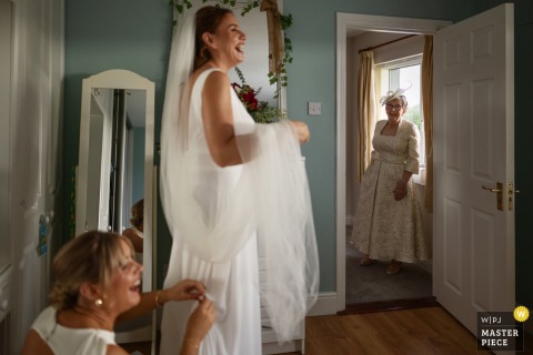 A Mother Watches Quietly, Filled With Emotion And Anticipation, As Bride Finishes Dressing At Family Home In Donegal Town. While the bride finishes getting dressed at her family home in Donegal Town, Ireland, her mother looks on quietly, filled with emotion and anticipation for the ceremony.