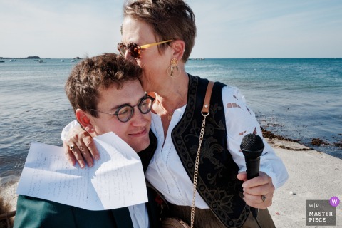 Genuine Connection Is Captured In Kerlouan As The Groom Shares A Touching Embrace With His Mother After Her Speech. In Kerlouan, a touching embrace takes place between a groom and his mother, immediately following her moving speech, encapsulating the emotion and connection of the occasion.