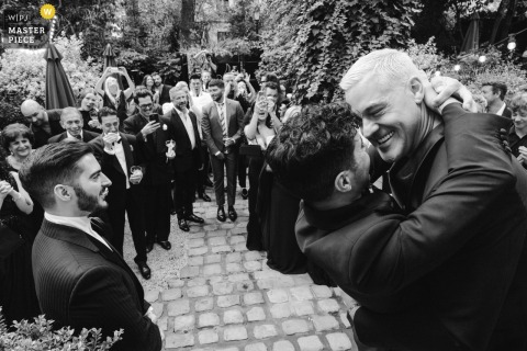   The first kiss at the outdoor wedding in Montmartre, Paris, brings tears to one groom’s eyes, marking an emotional and tender highlight of the celebration.