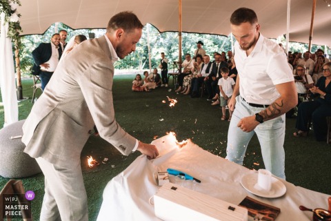   A candle ignites a wedding table in Chignat, France, prompting quick action from the groom and his father, who work together to stop the fire during the lively event.