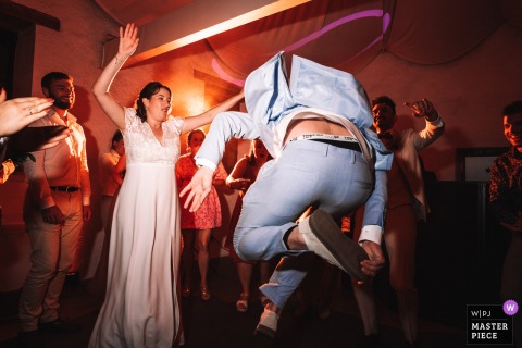   With feet lifted high and a joyful leap, a guest entertains the bride on the dancefloor of Chateau de Vinzellesony, France, energizing the evening’s celebration for everyone.